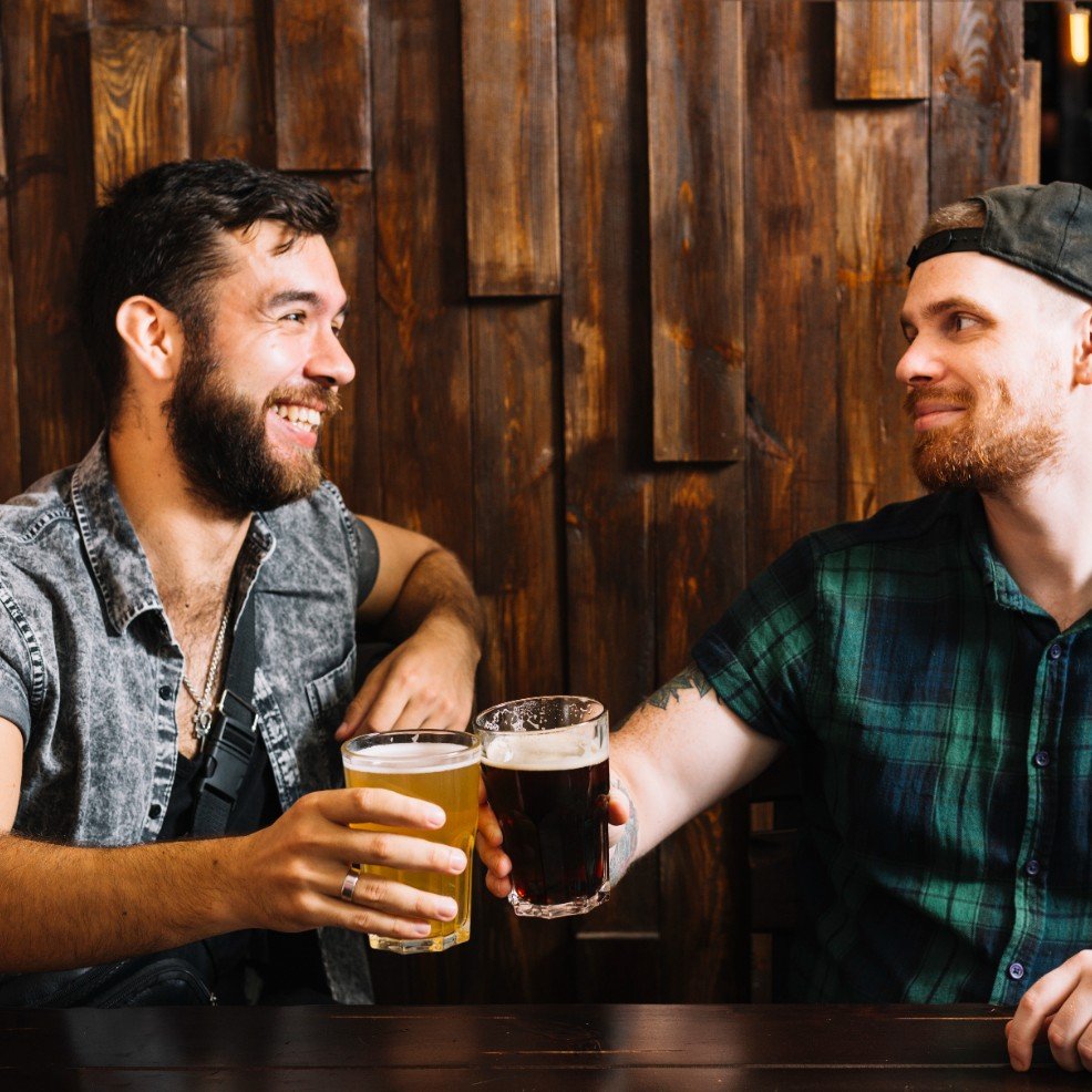 Deux hommes se souriant en train de boire un verre